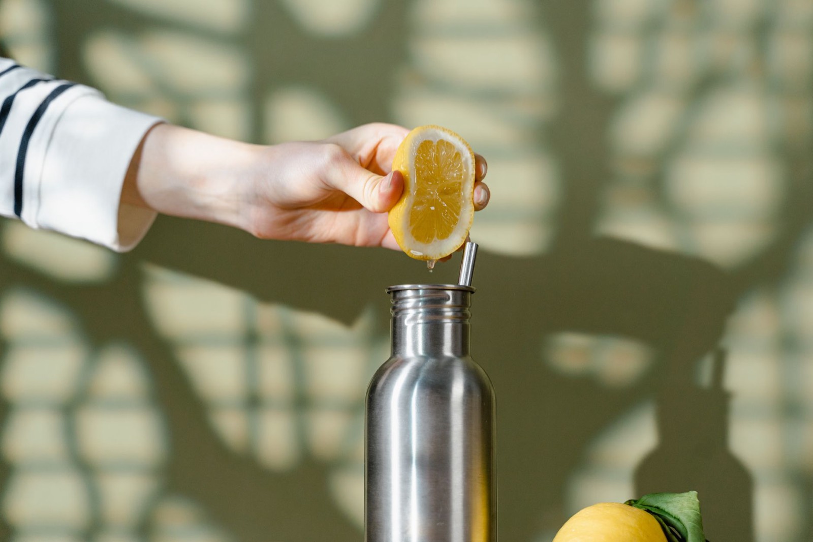 Bouteille en inox dans laquelle on verse un jus fraîchement pressé