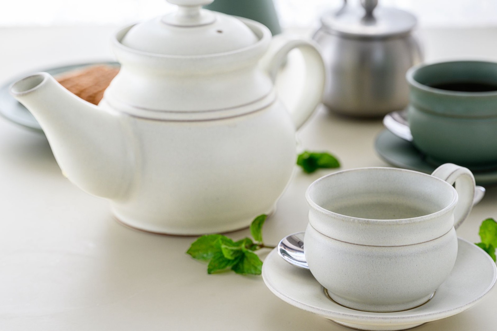 tasse de tisane aux feuilles de menthe posée sur une table en bois