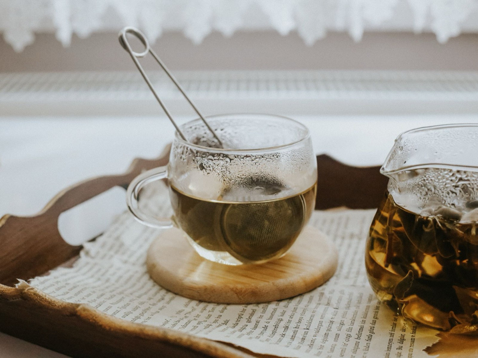 tasse en bois remplie de tisane aux herbes posée sur une table