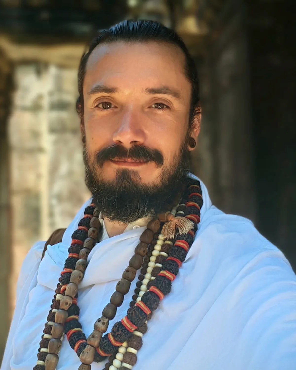 Sri Satpremananda Maharaj en robe blanche portant plusieurs mâlâs de rudraksha